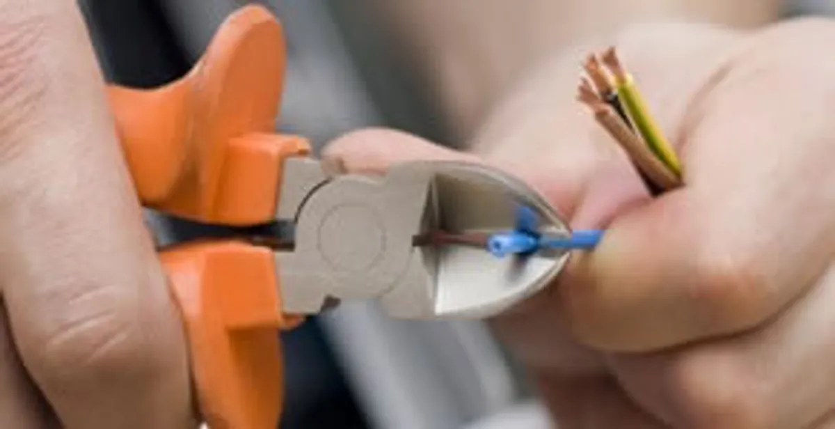 licensed electrician performing precise wire cutting and preparation during electrical service in Orlando, FL