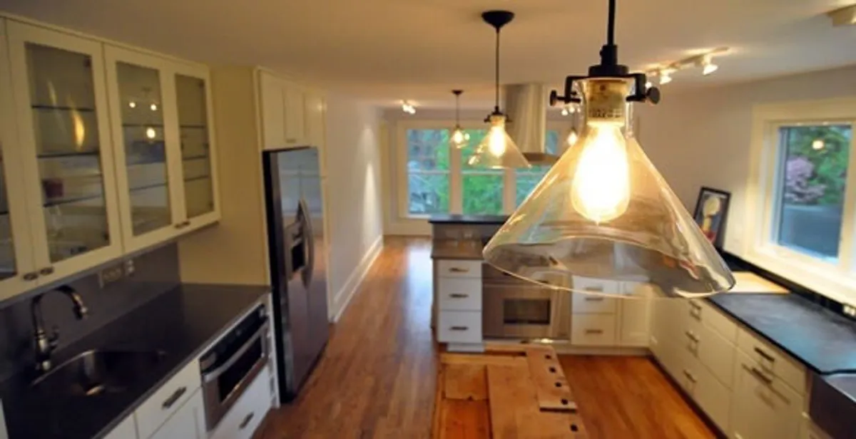 Residential electrician installing modern indoor light fixture in a home in Orlando, FL
